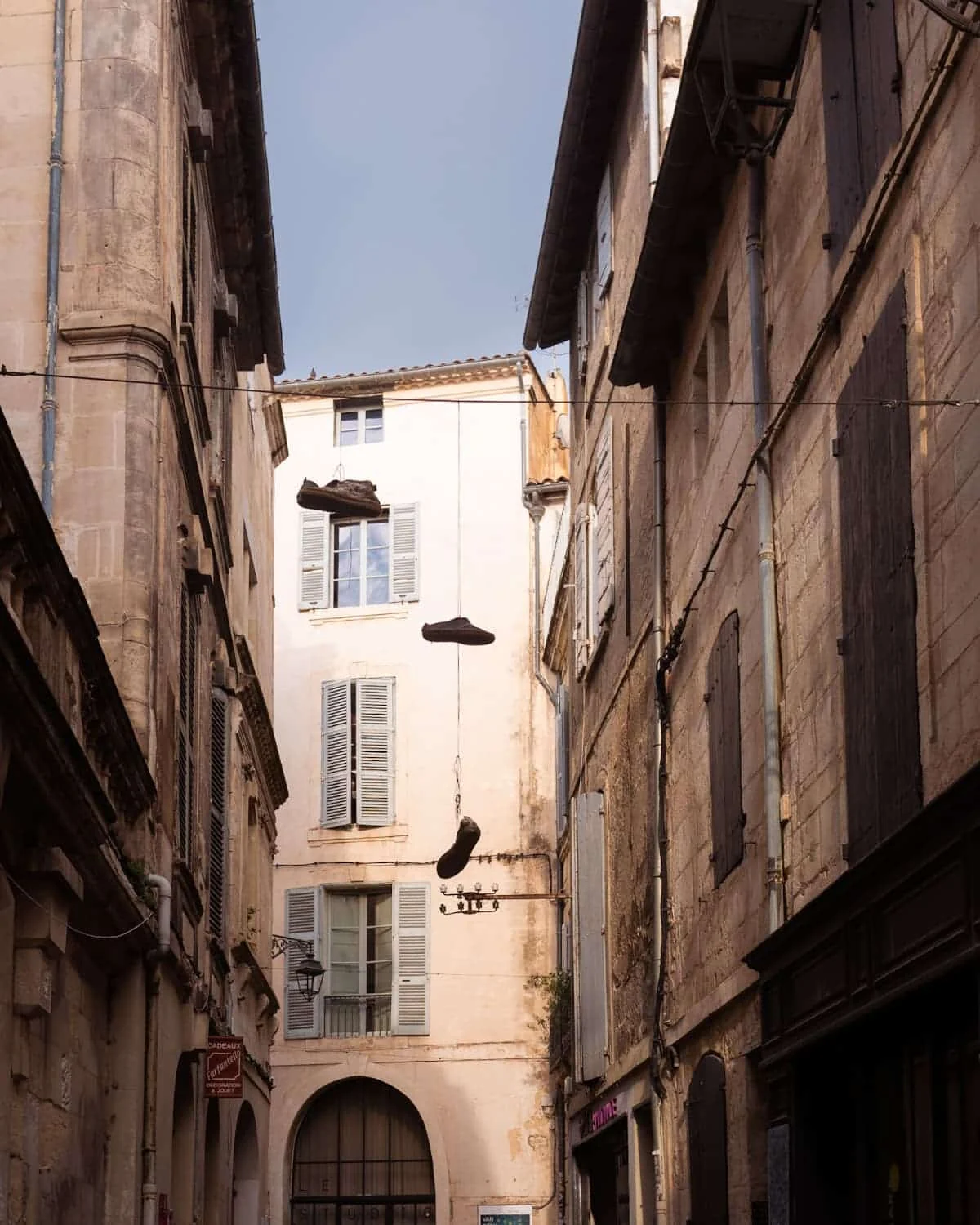 Arles building with shoes hanging over wire