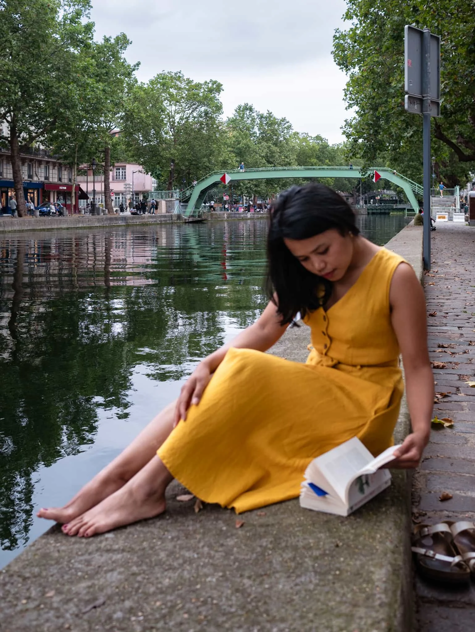 Parisian girl reading book at Canal Saint Martin, Paris