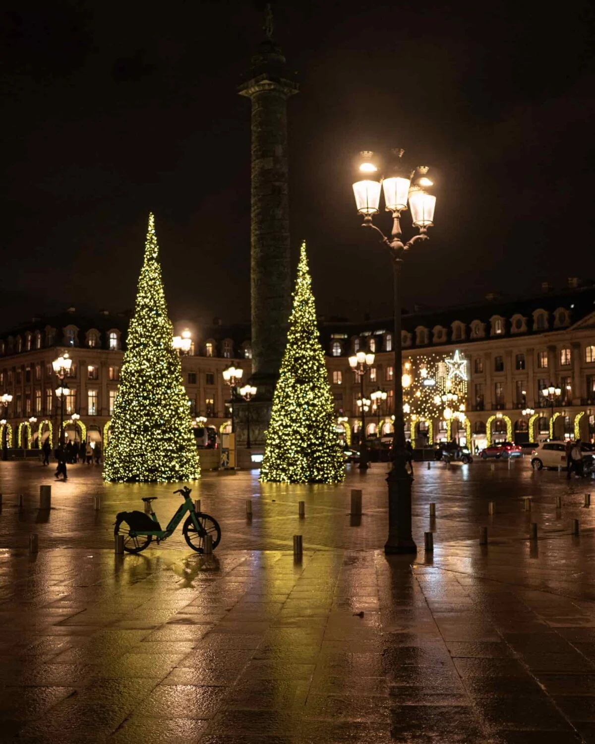 A cycle parked in front of giant decorated Christmas trees