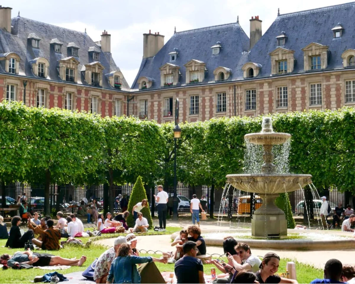 Parisian siting in the sun at Places des Vosges Paris