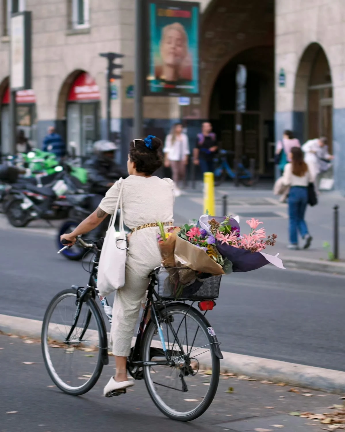 A Paris biker with a bouquet of flowers on her backseat