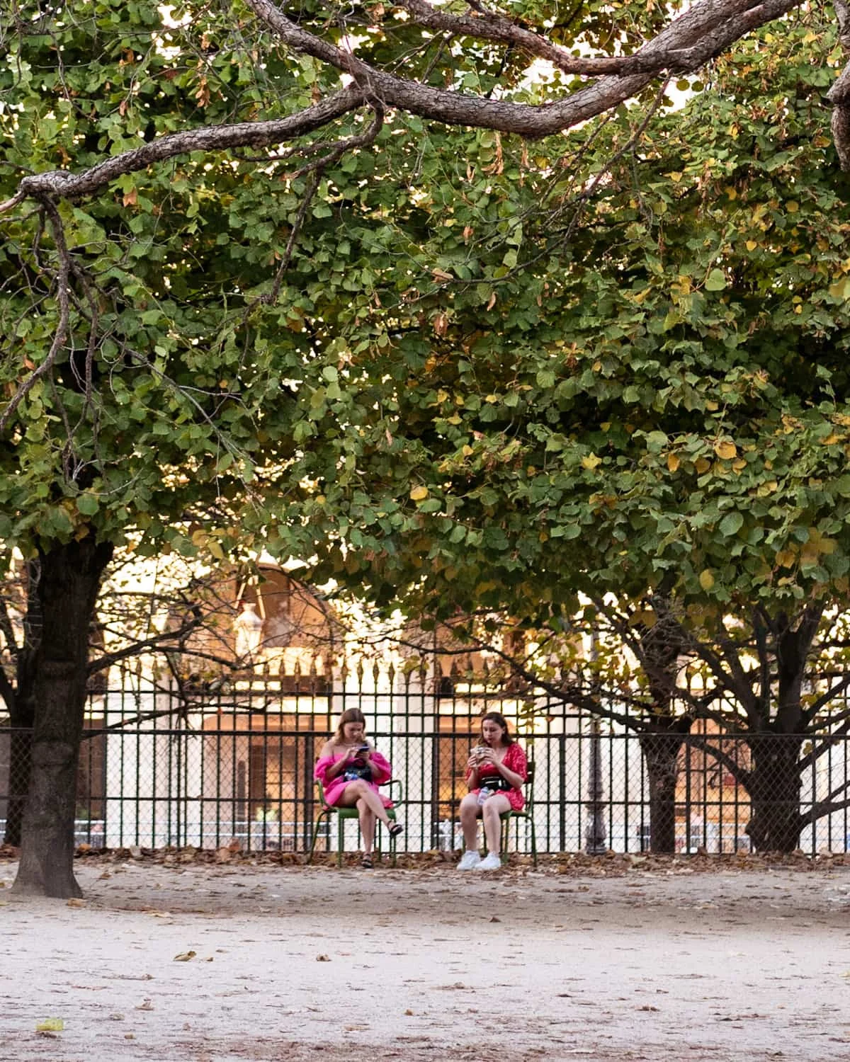 Two women in pink sitting on a bench at Jardin des Tuileries