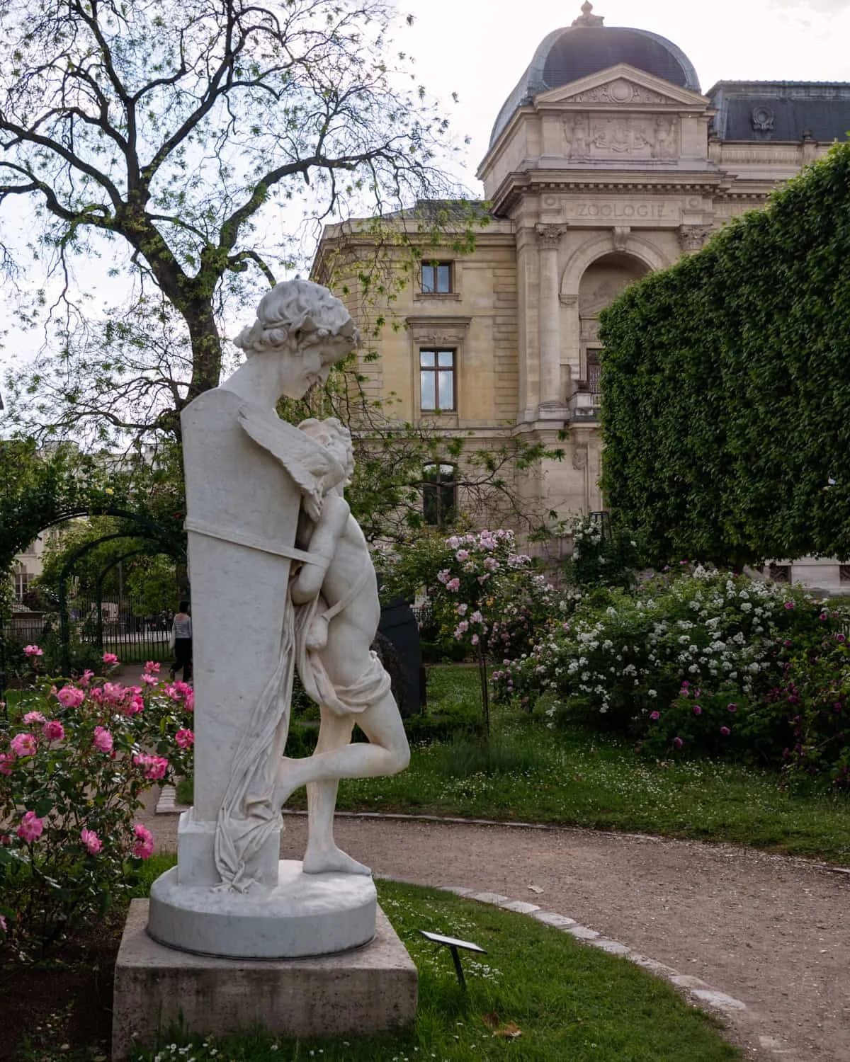 A Paris statue surrounded by blooming roses
