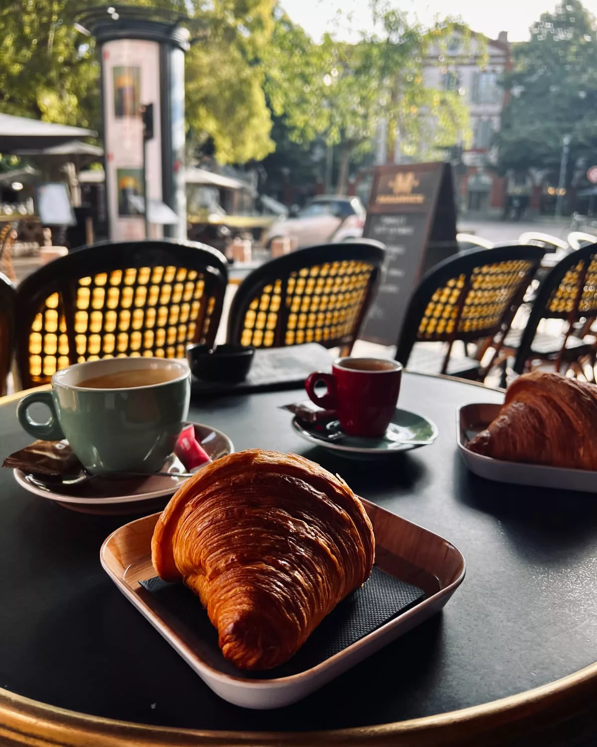 A croissant and coffee on a café table