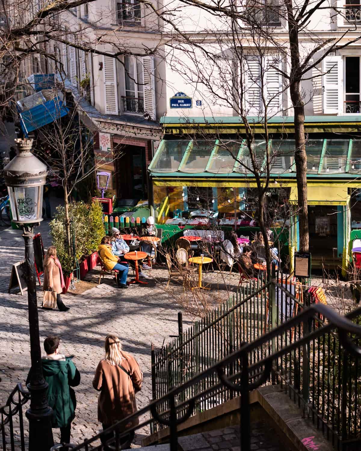 Paris cafe terrace in Montmartre with tourists and locals enjoying the sun