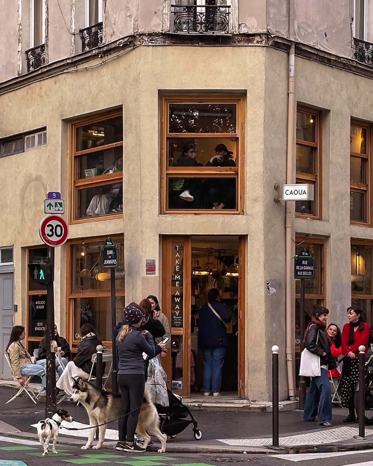 The entrance to a Paris café with a lot of people standing outside