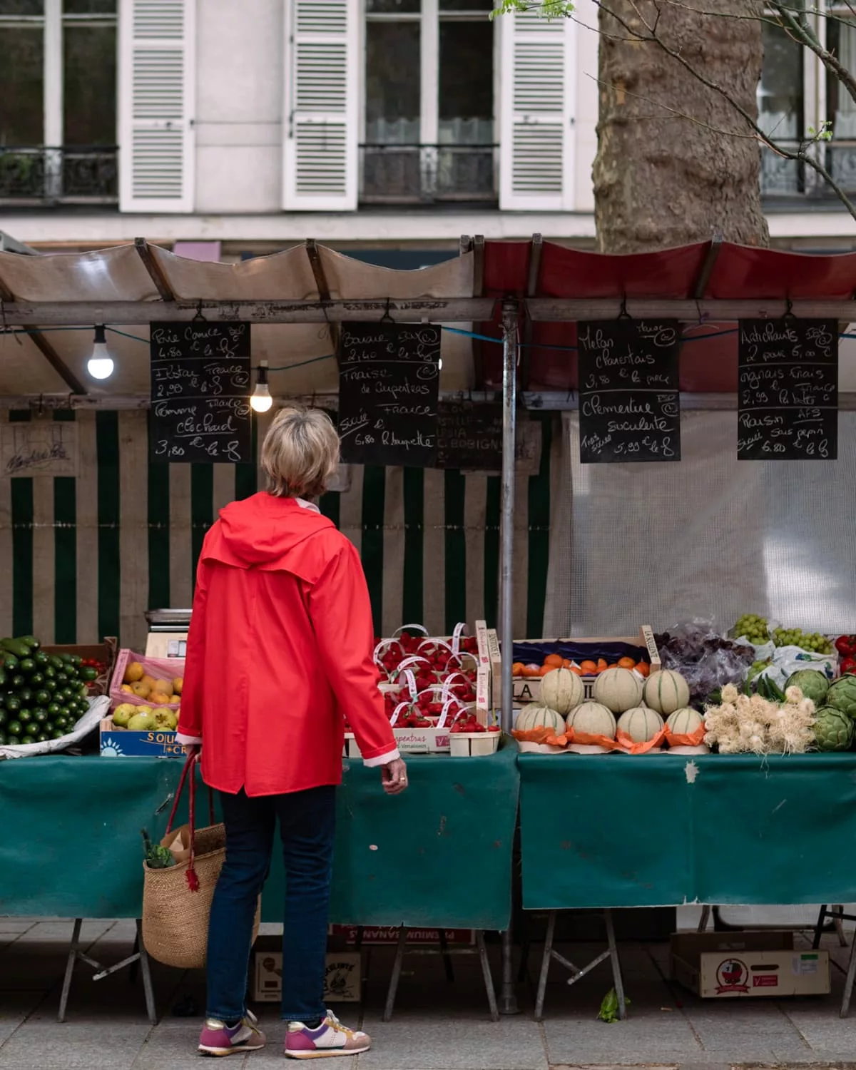 A woman shopping for vegetables at a farmer's market in Paris