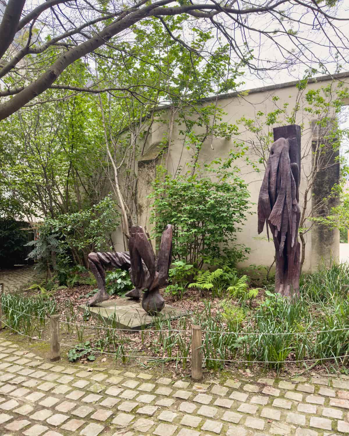 Sculptures surrounded by trees and plants in Anne Frank garden
